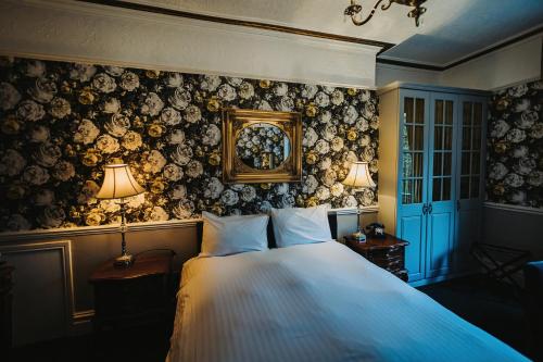 a bedroom with a large bed with two lamps on it at Brook Hall Hotel in Childer Thornton