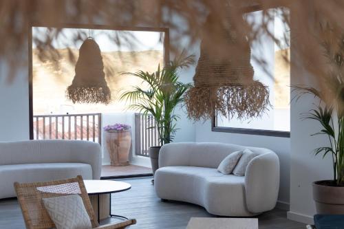 a living room with two white couches and plants at Comitas Tramontana Park in Fornells