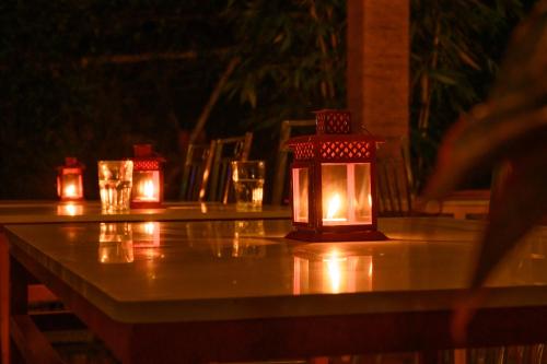 a table with a lantern on top of it at Anandavana Jungle Living By LexStays - Kanthalloor-Marayur in Kanthalloor
