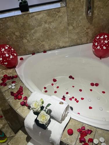 a bath tub filled with red roses on the floor at Maupa Mountain view in Krugersdorp