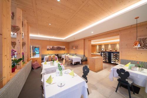 a dining room with white tables and chairs at Hotel Ortler in Castelrotto