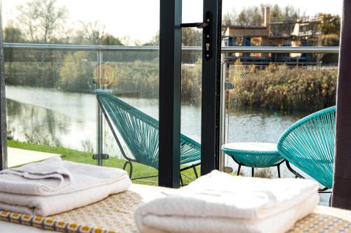 a room with a balcony with a view of the water at Family friendly property in nature reserve The Hangout ML15 in Somerford Keynes
