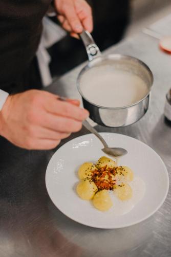 a person with a spoon and a plate of food at Corippo Albergo Diffuso in Corippo