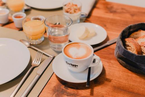 a cup of coffee on a table with plates and utensils at Corippo Albergo Diffuso in Corippo