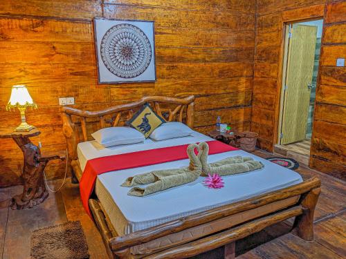 1 dormitorio con 1 cama con toallas en Choona Lodge 'view of sigiriya & pidurangala with sunrise', en Sigiriya