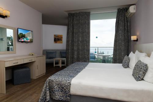 a hotel room with a bed and a large window at Hotel Slavey - All Inclusive in Golden Sands