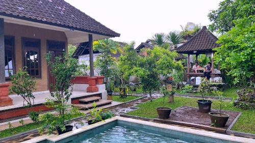 a house with a swimming pool in front of a house at Gusti Home Stay Ubud in Ubud
