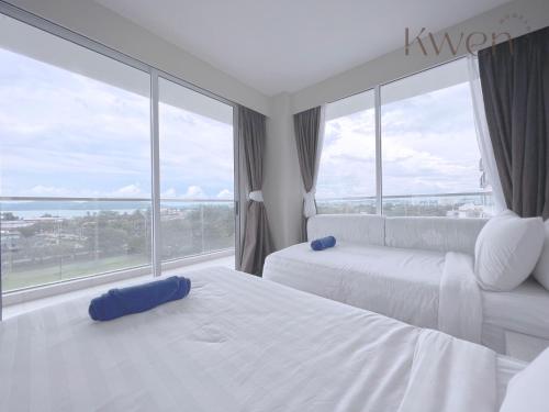 a hotel room with two beds and a large window at KWEN Suites-Tanjung Aru InfinityPool Seaview/Airport View in Kota Kinabalu