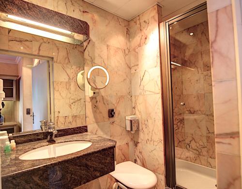 a bathroom with a sink and a shower at Hôtel Du Midi Paris Montparnasse in Paris