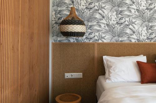 1 dormitorio con cama y pared con estampado de flores en GD Gallery Suites en Heraclión