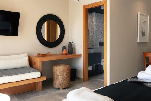 伊拉克利翁鎮的住宿－GD Gallery Suites，一间带镜子、一张床和凳子的卧室