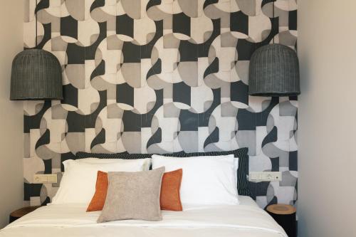 a bedroom with a bed with a patterned wall at Chapter 02 Gallery Suites - ex GD Gallery Suites in Heraklio Town