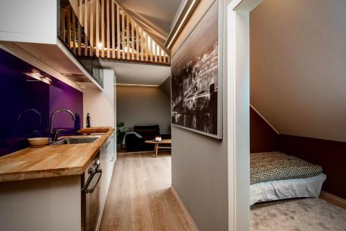 una pequeña cocina con fregadero y una cama en una habitación en Nyrenovert leiliget 1 min unna solsiden, en Trondheim