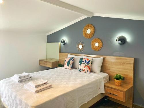 1 dormitorio con cama y espejo en la pared en Shared Pool Flat Located 3 Min to Beach in Kalkan, en Kalkan