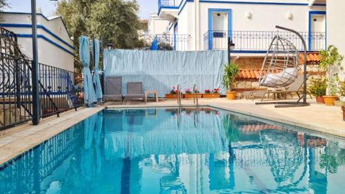 una piscina de agua azul en una casa en Shared Pool Flat Located 3 Min to Beach in Kalkan, en Kalkan