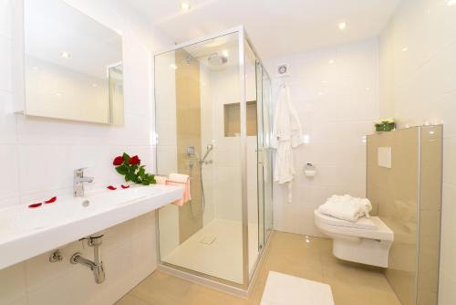 ein Badezimmer mit Dusche, Waschbecken und Toilette in der Unterkunft Hotel am Buchwald in Esslingen