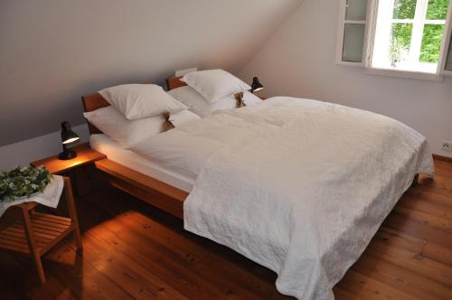 Schlafzimmer mit einem Bett mit weißer Bettwäsche und einem Fenster in der Unterkunft Weinberg 12 in Fehring
