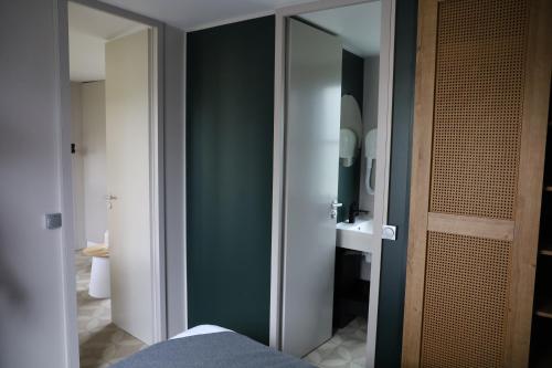 baño con pared verde y espejo en Vakantiepark Delftse Hout, en Delft