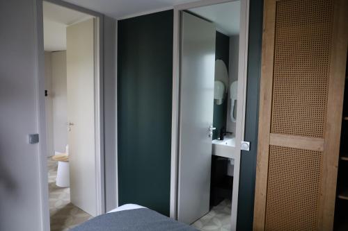 een badkamer met een groene muur en een spiegel bij Vakantiepark Delftse Hout in Delft