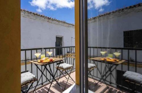 Un balcón con dos mesas con comida. en El Mirador de El Puerto, en El Puerto de Santa María