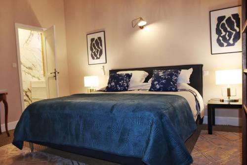 a bedroom with a bed with a blue comforter at CARCASSONNE HISTORIC DUPLEX 4 star air conditioned APARTEMENT d`ÉGLANTINE in Carcassonne