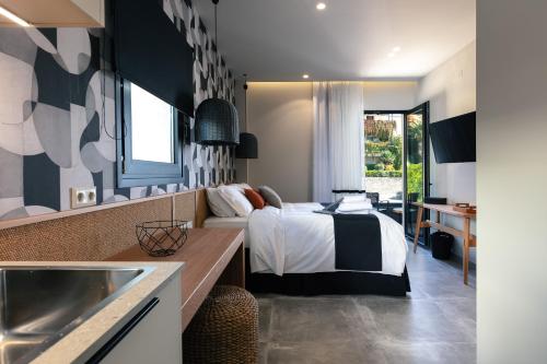 a bedroom with a bed and a kitchen with a sink at Chapter 02 Gallery Suites - ex GD Gallery Suites in Heraklio Town