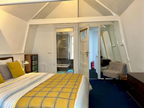 1 dormitorio con 1 cama extragrande y 1 silla en Amsterdam 4 Holiday GuestRooms, en Ámsterdam