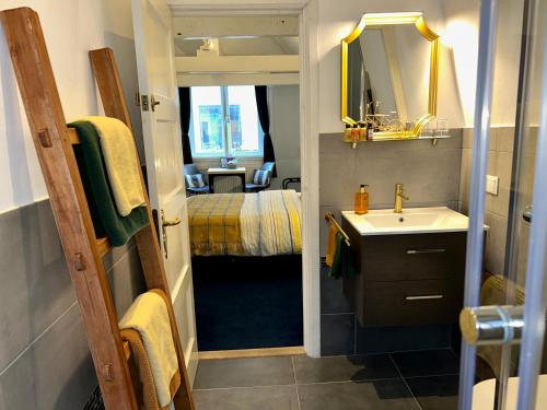 a small bathroom with a sink and a mirror at Amsterdam 4 Holiday GuestRooms in Amsterdam