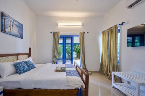 a bedroom with a bed and a door to a patio at Seclude by the Lake, Alleppey in Alleppey