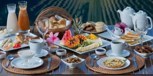 una mesa cubierta con platos de comida y bebida en Pousada Mangabeiras, en Isla de Boipeba