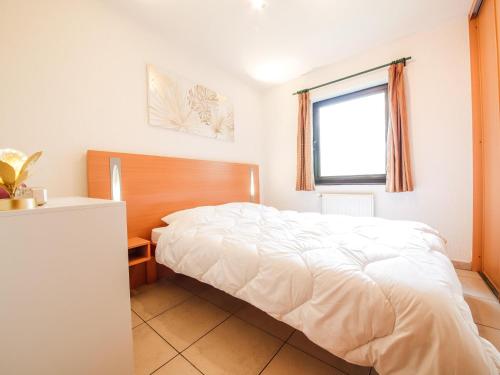 una camera con un letto bianco e una finestra di Apartment with a view of Durbuy Golf Course a Barvaux-sur-Ourthe