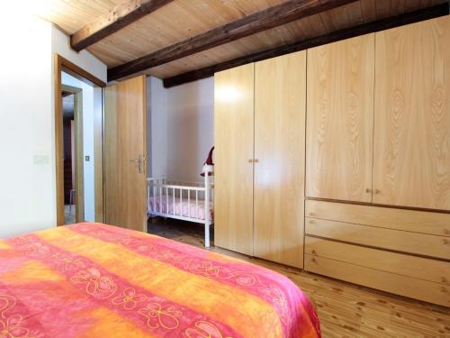 een slaapkamer met een bed en een grote houten kast bij Wooden chalet in Pieve Tesino with garden in Pieve Tesino