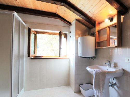 een badkamer met een wastafel en een raam bij Wooden chalet in Pieve Tesino with garden in Pieve Tesino