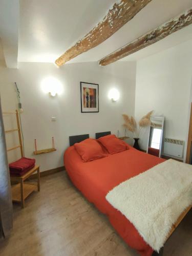 une chambre avec un grand lit avec des oreillers rouges dans l'établissement Maison de ville au coeur du centre historique, parking gratuit, à Apt