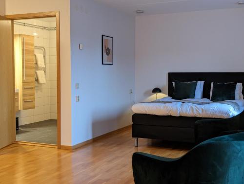 ein Schlafzimmer mit einem Bett und einem Spiegel sowie ein Badezimmer in der Unterkunft Hotell Bro in Kristinehamn
