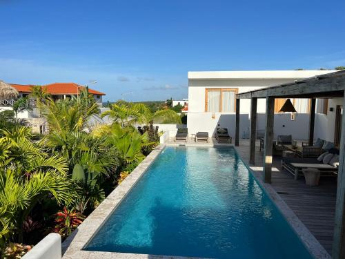 a swimming pool in front of a house at Villa Ban Kas Curaçao in Jan Thiel