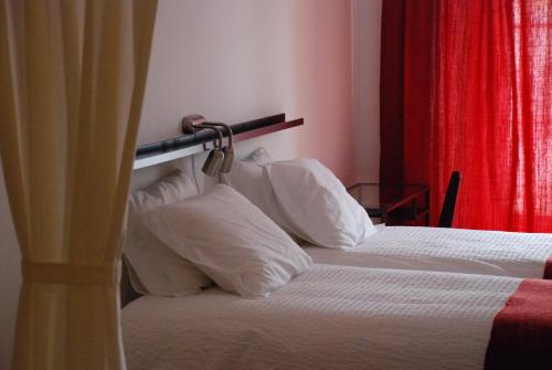 two beds with white pillows in a hotel room at StayInn City - Évora in Évora