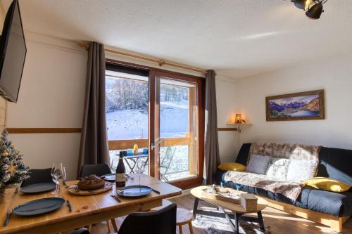 un salon avec une table et un canapé dans l'établissement Aux Rêveries des Cimes - Vostok Zodiaque, à Villarembert