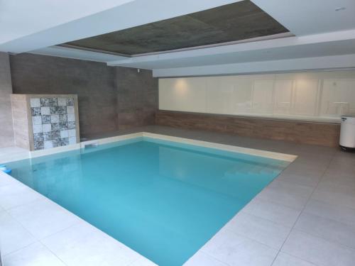 a large swimming pool with blue lighting in a room at Gran Hotel Dakar in Mendoza