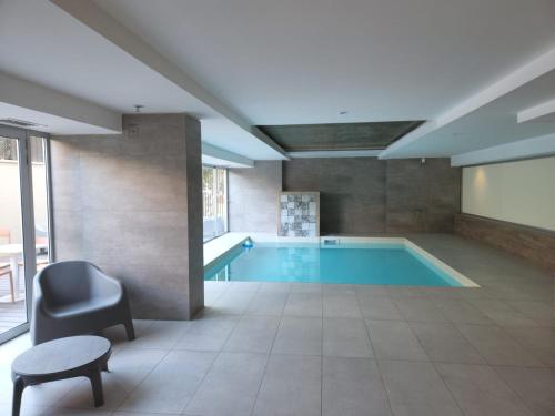 una gran piscina con una silla y una mesa en Gran Hotel Dakar en Mendoza