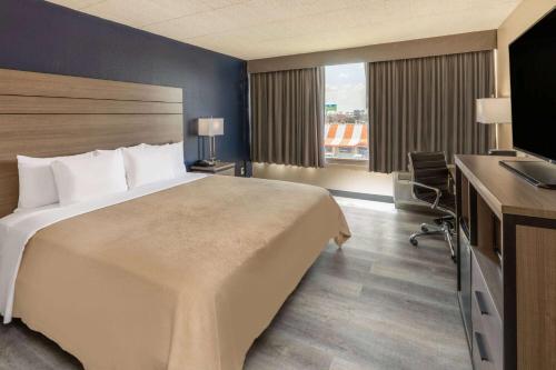 a hotel room with a large bed and a desk at Baymont by Wyndham Laredo in Laredo
