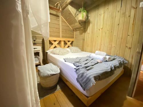 1 dormitorio con 1 cama en una habitación de madera en Pousada Anjos da Serra, en Urubici