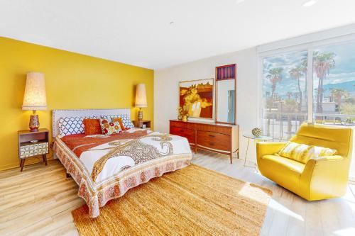 sypialnia z dużym łóżkiem i żółtym krzesłem w obiekcie Upscale Uptown Permit# 5251 w mieście Palm Springs