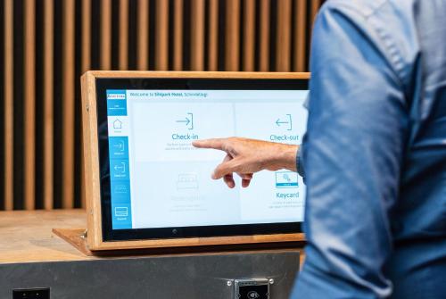a man is pointing at a computer screen at Tailormade Hotel SIHLPARK Schindellegi in Schindellegi