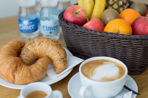a table with a cup of coffee and a basket of fruit at Tailormade Hotel SIHLPARK Schindellegi in Schindellegi