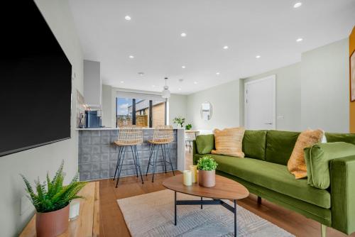 a living room with a green couch and a table at Be London - The London Residences in London