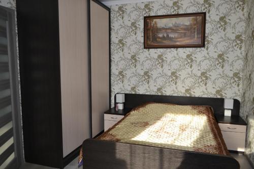 a bedroom with a bed and a painting on the wall at Apartments on Primorskaya in Zelenogradsk