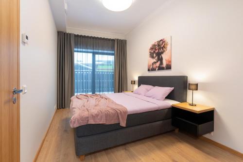 a bedroom with a bed with pink sheets and a window at TartuKodu Riia 20A-5 in Tartu
