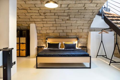 a bedroom with a bed and a brick wall at Modernes Loft mit Sandstein-Gewölbe im Zentrum in Pirna