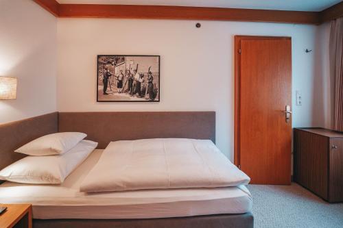 a bedroom with a bed with a picture on the wall at Hotel Garni Almjur in Sankt Anton am Arlberg